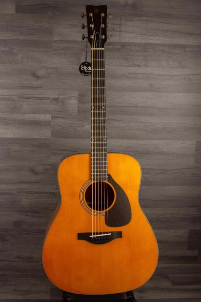 Yamaha FG5G - Acoustic Guitar displayed against a wooden backdrop, showcasing its solid sitka spruce top and African mahogany body.