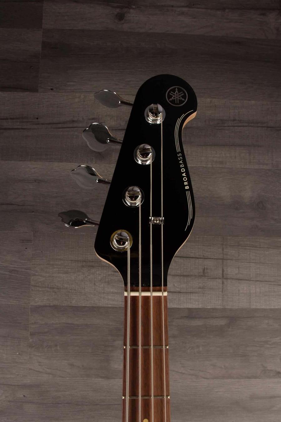 Yamaha BB434 Sunburst guitar headstock with tuning pegs and logo on a wooden surface.