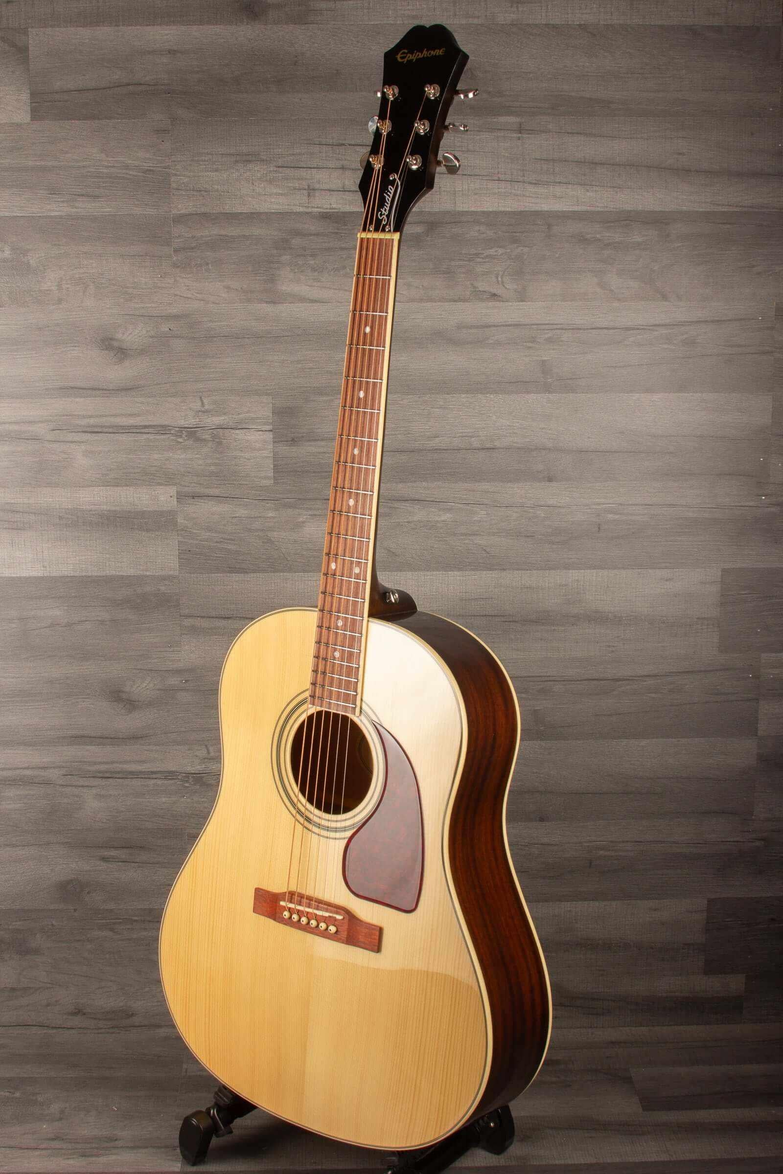 Epiphone J45 Studio Solid Top - Natural, Acoustic Guitar showcased against a wooden backdrop.