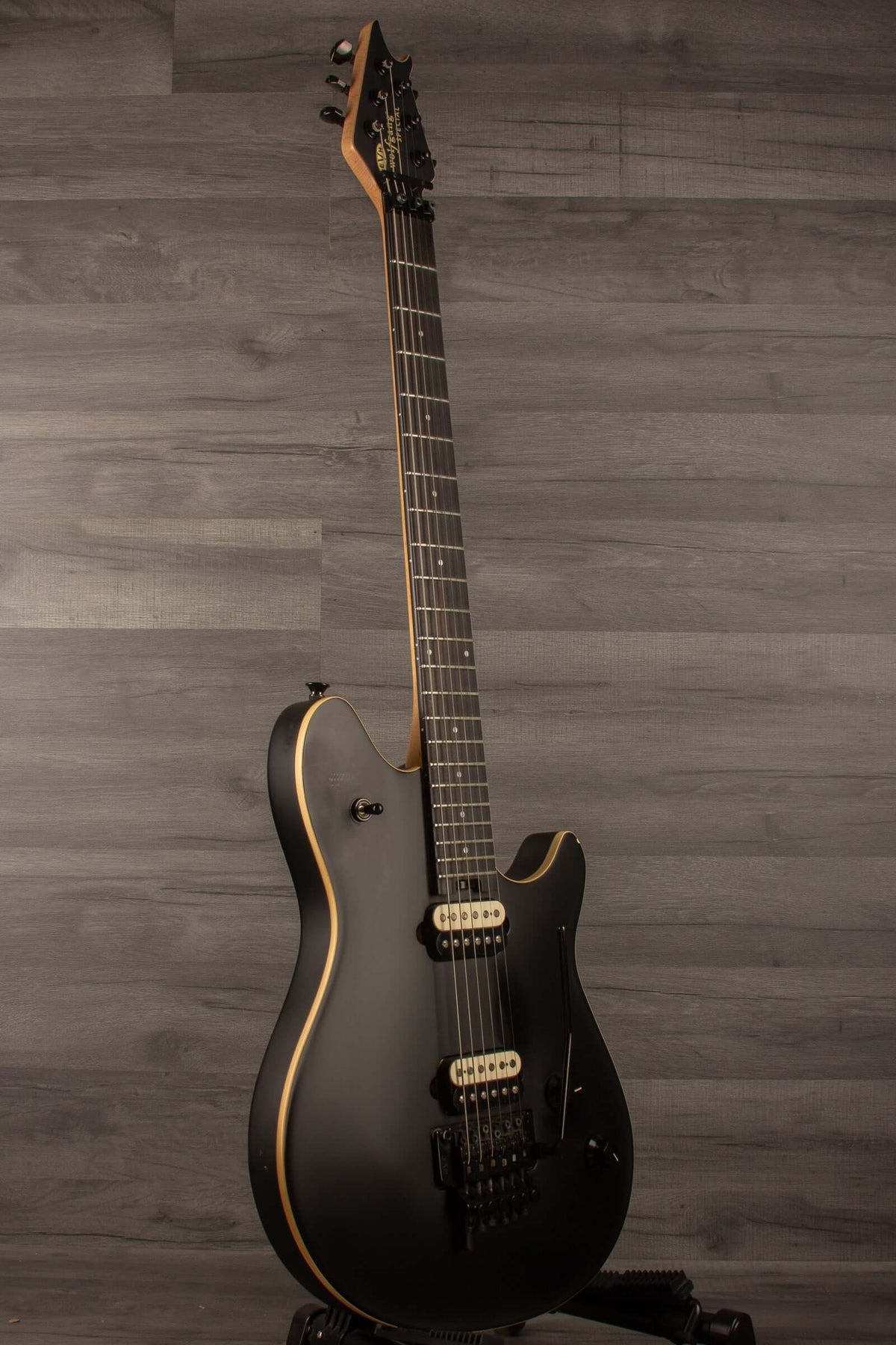 USED - EVH Wolfgang Special Stealth - Black (inc EVH hard case) guitar side view on wooden background.