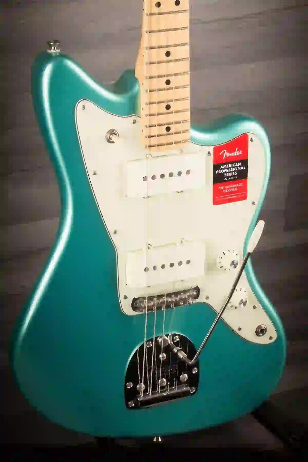 Close-up of a Fender guitar with a turquoise body and white pickguard, showcasing its unique design and features.