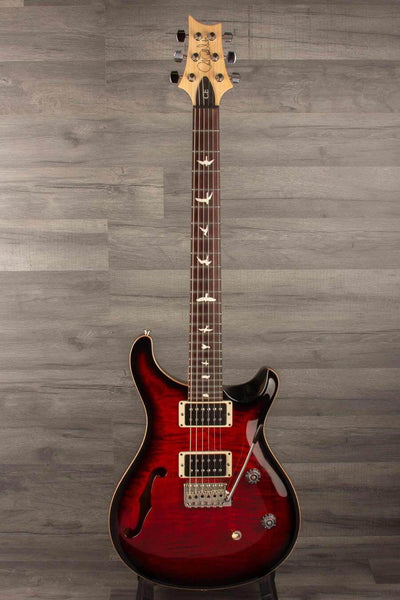 USED - PRS CE24 Semi Hollow - Fire Red shown against a wooden background with F-hole and intricate fretboard inlays.