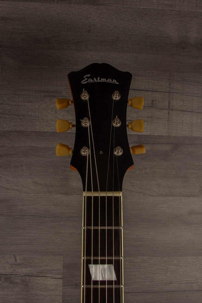 USED - Eastman T64/V Antique Varnish guitar headstock with tuning pegs and logo on wood background.