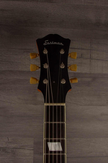 USED - Eastman T64/V Antique Varnish guitar headstock with tuning pegs and logo on wood background.